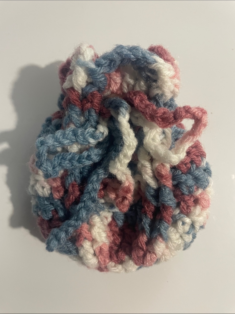 Miniature mauve, white, and blue-gray colored pouch
